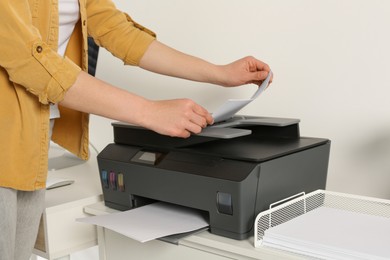 Photo of Woman using modern printer at home, closeup