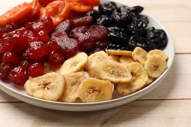 Delicious dried fruits on white wooden table, closeup