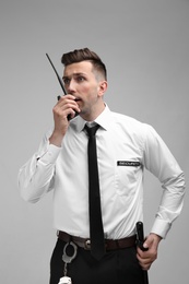 Photo of Male security guard using portable radio transmitter on color background