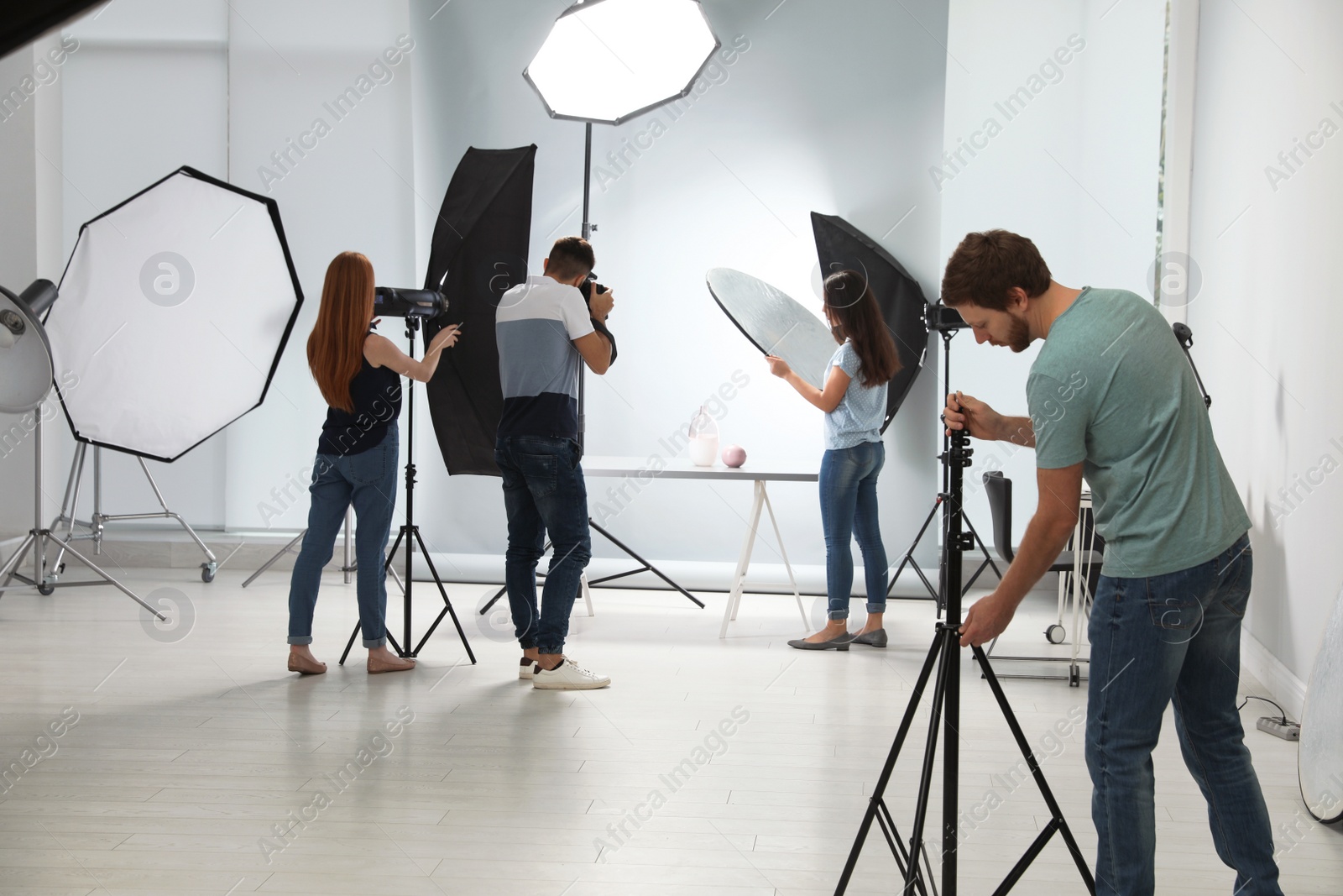 Photo of Photo studio with professional equipment and team of workers