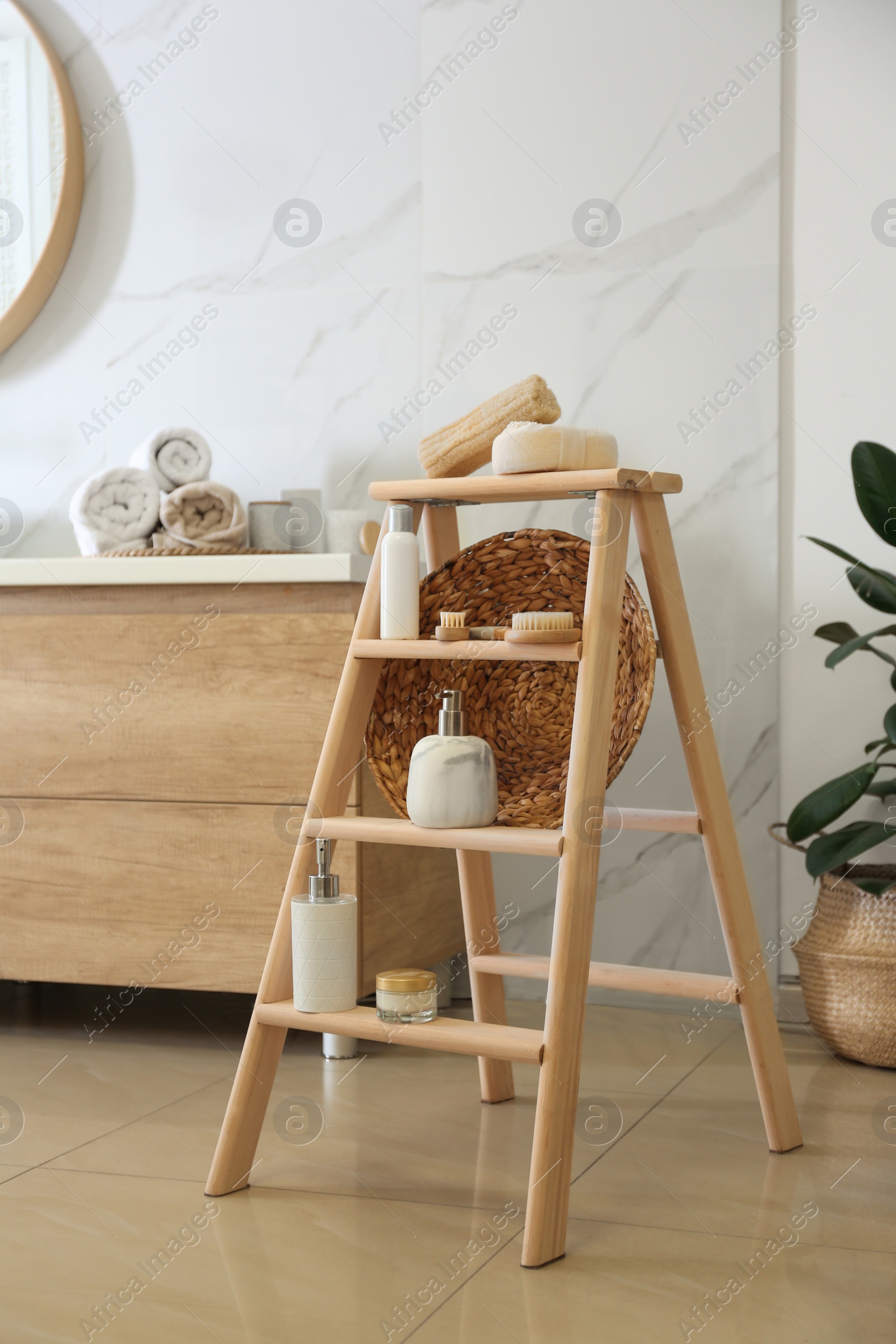 Photo of Dispensers and different toiletries on decorative ladder in bathroom. Idea for interior design