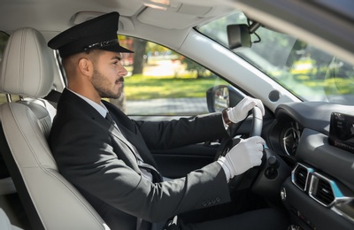 Young handsome driver in luxury car. Chauffeur service