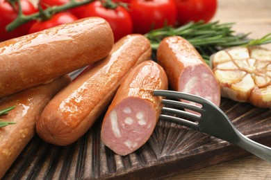 Photo of Delicious vegan sausages served on wooden table, closeup
