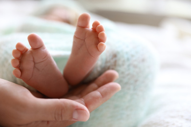 Mother and her newborn baby on white plaid, closeup