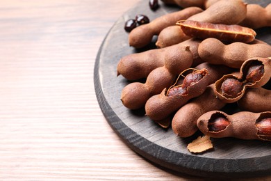 Photo of Delicious ripe tamarinds on wooden table. Space for text