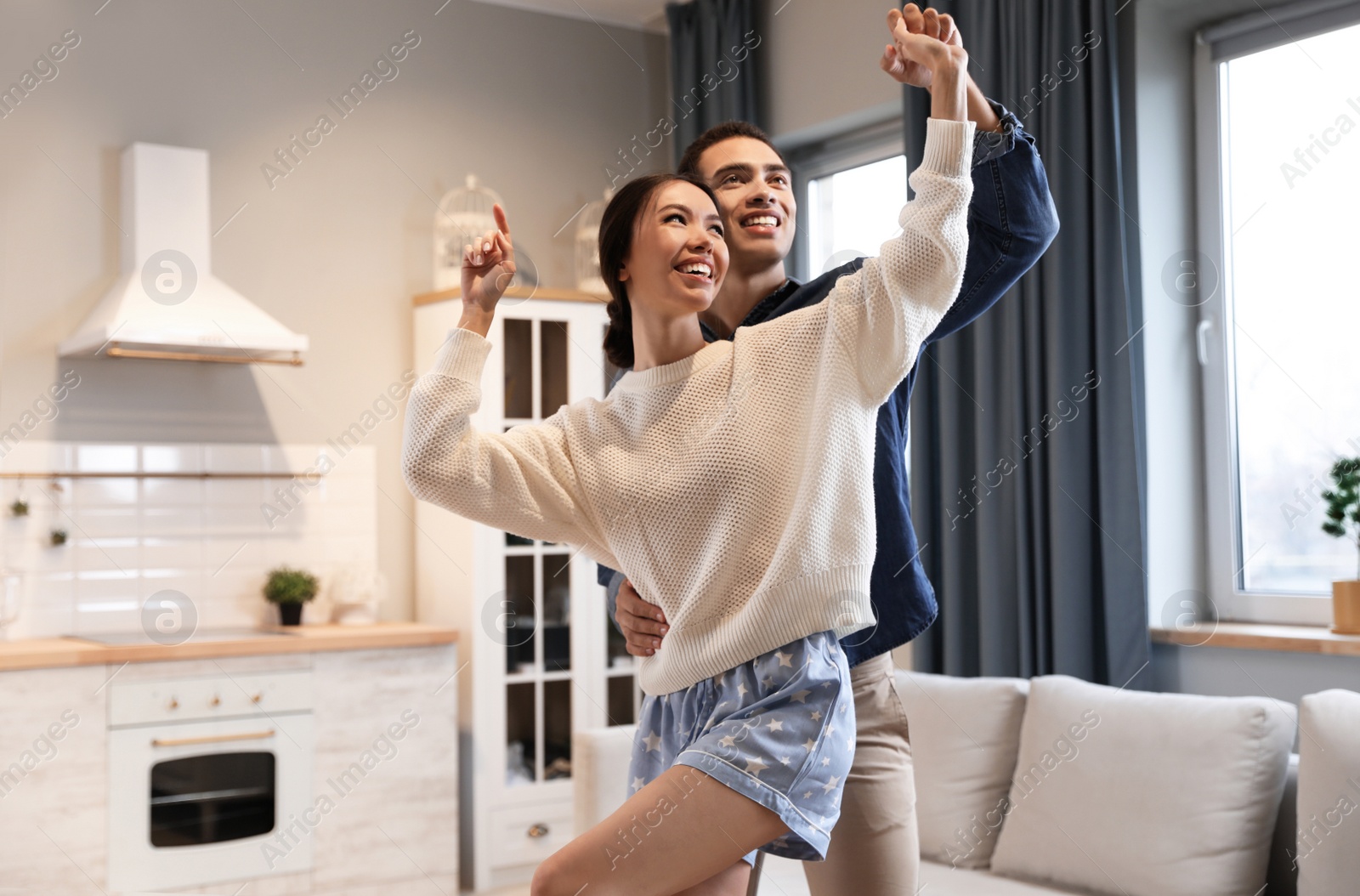 Photo of Lovely young interracial couple dancing at home