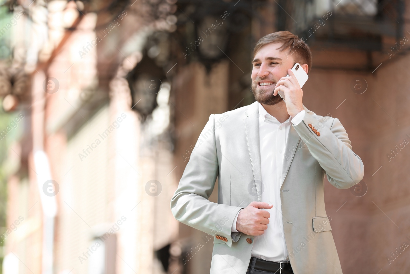 Photo of Portrait of young businessman talking on phone outdoors