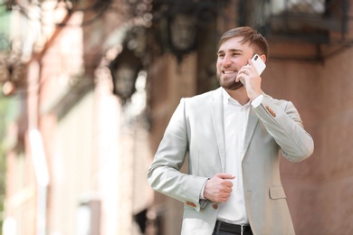 Portrait of young businessman talking on phone outdoors