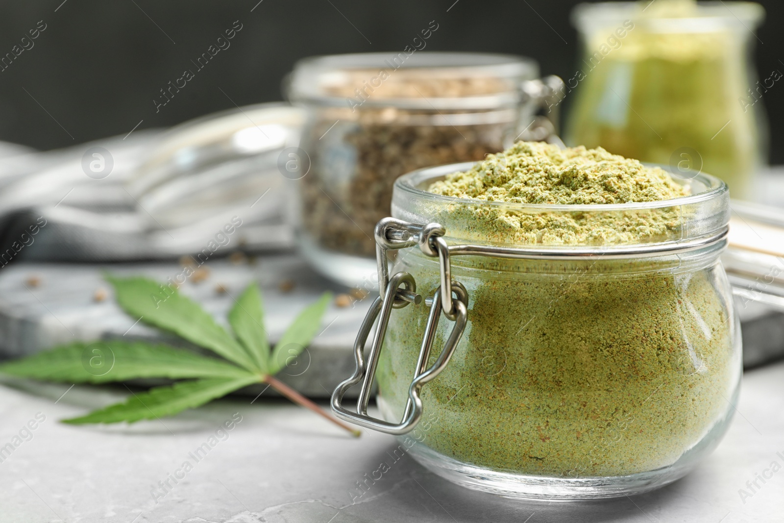 Photo of Composition with jar of hemp protein powder on light table. Space for text
