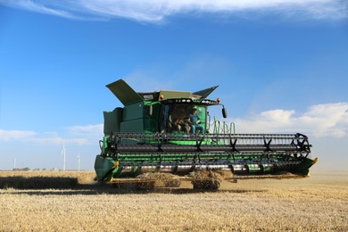 Modern combine harvester working in agricultural field