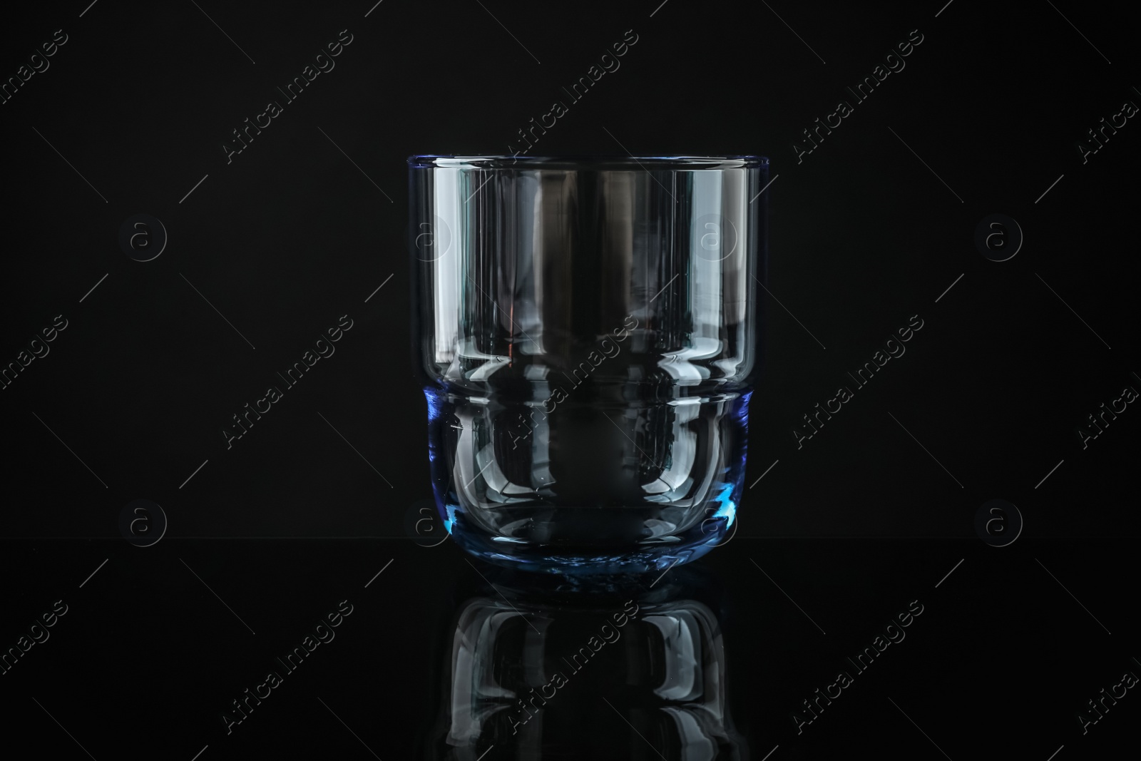 Photo of Elegant empty colorful whiskey glass on black background