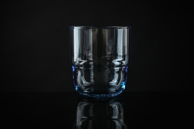 Photo of Elegant empty colorful whiskey glass on black background