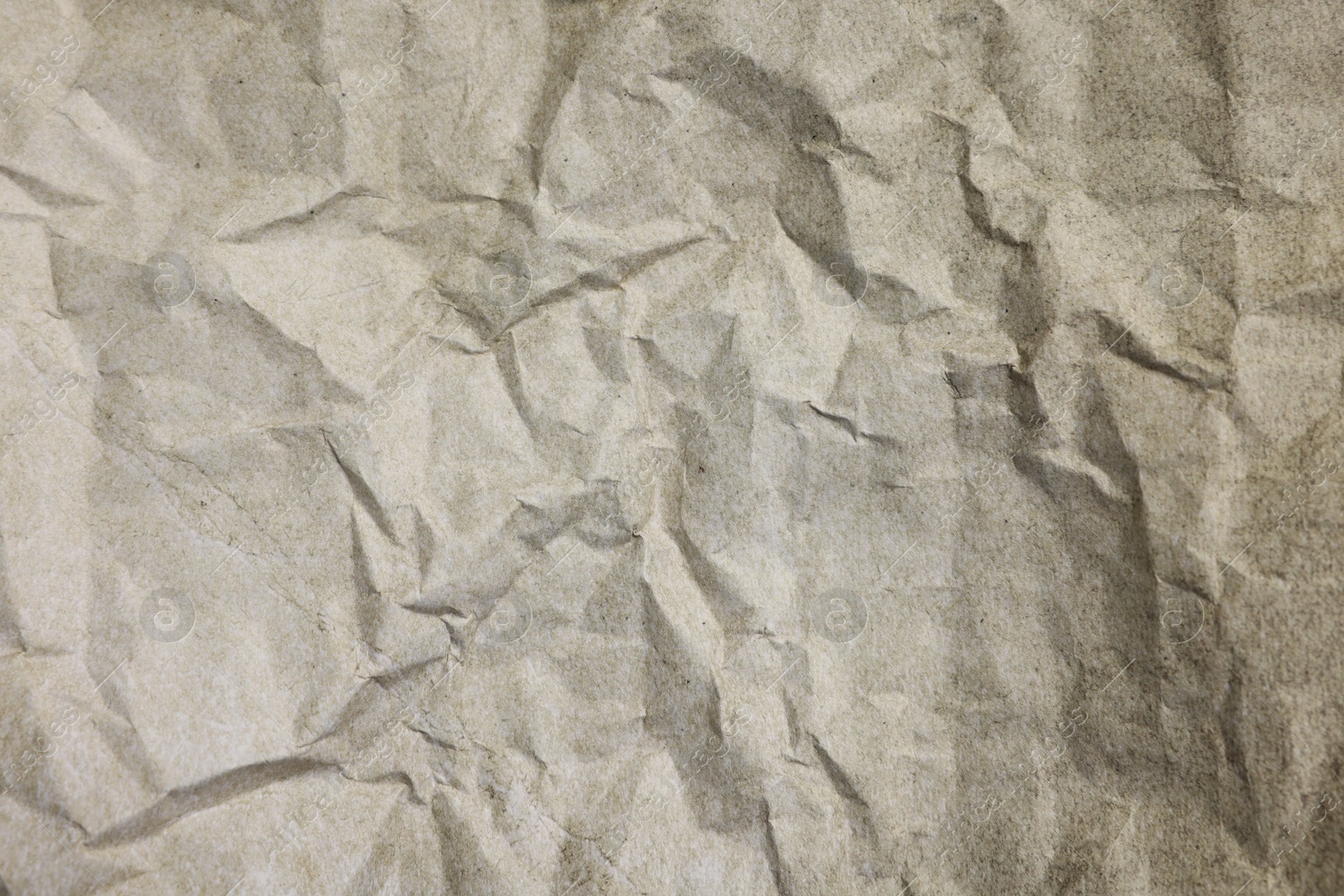 Photo of Texture of crumpled parchment paper as background, top view