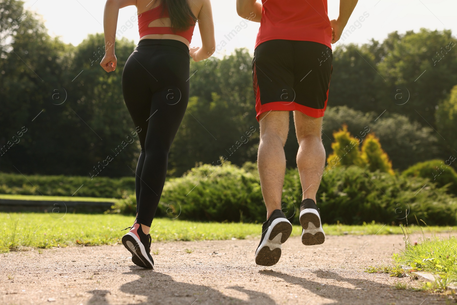 Photo of Healthy lifestyle. Couple running outdoors on sunny day, closeup