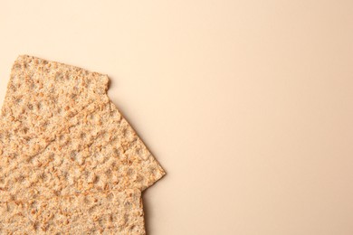 Photo of Fresh crunchy crispbreads on beige background, flat lay. Space for text