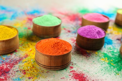 Photo of Colorful powder dyes on light background, closeup. Holi festival