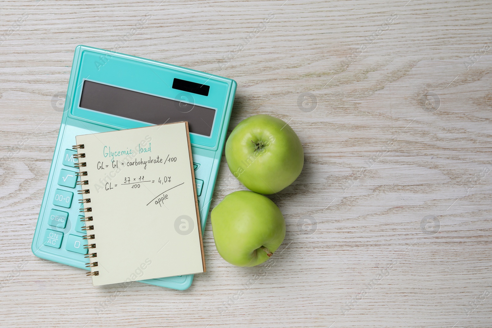 Photo of Notebook with calculated glycemic load for apples, calculator and fresh fruits on light wooden table, flat lay. Space for text