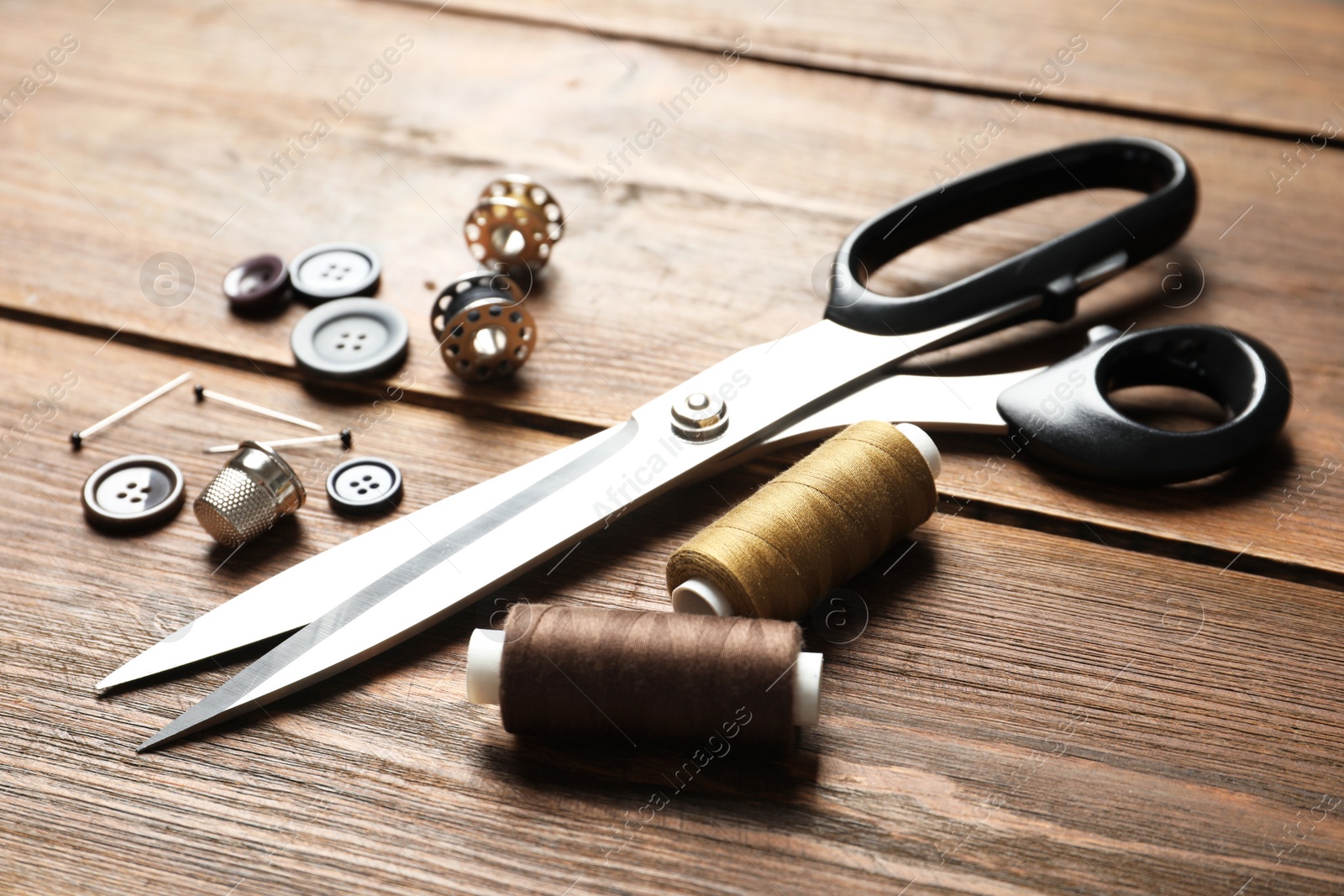 Photo of Set of tailoring accessories on wooden background