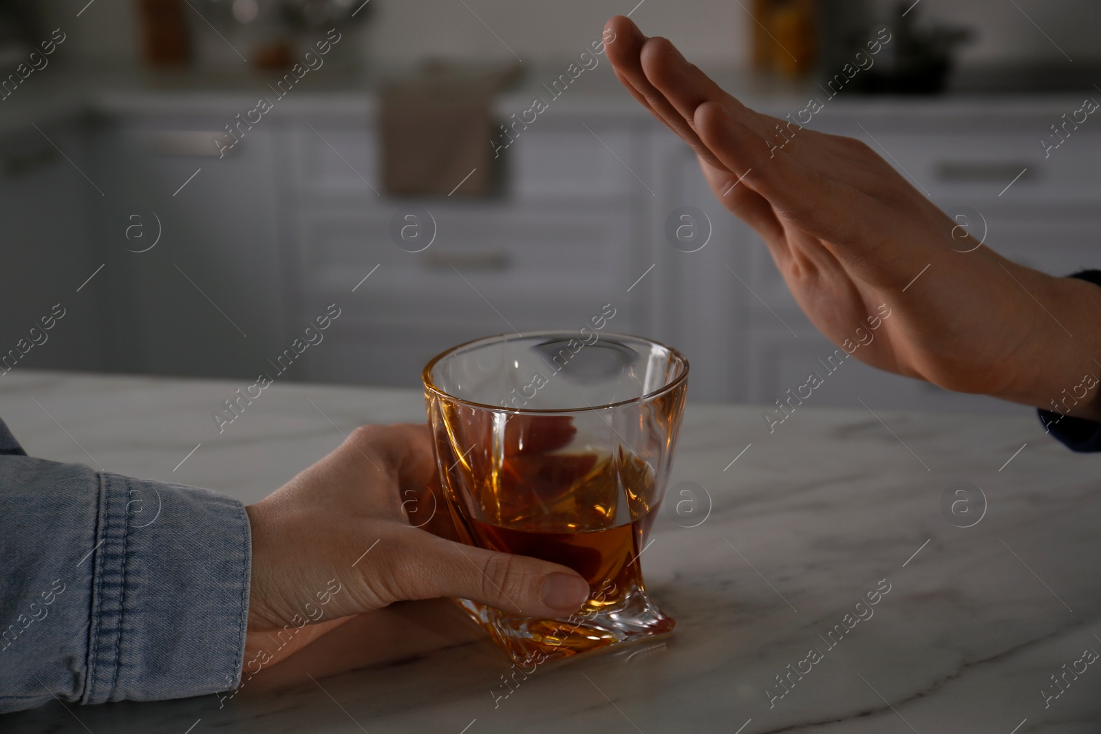 Photo of Man refusing to drink whiskey at home, closeup. Alcohol addiction treatment