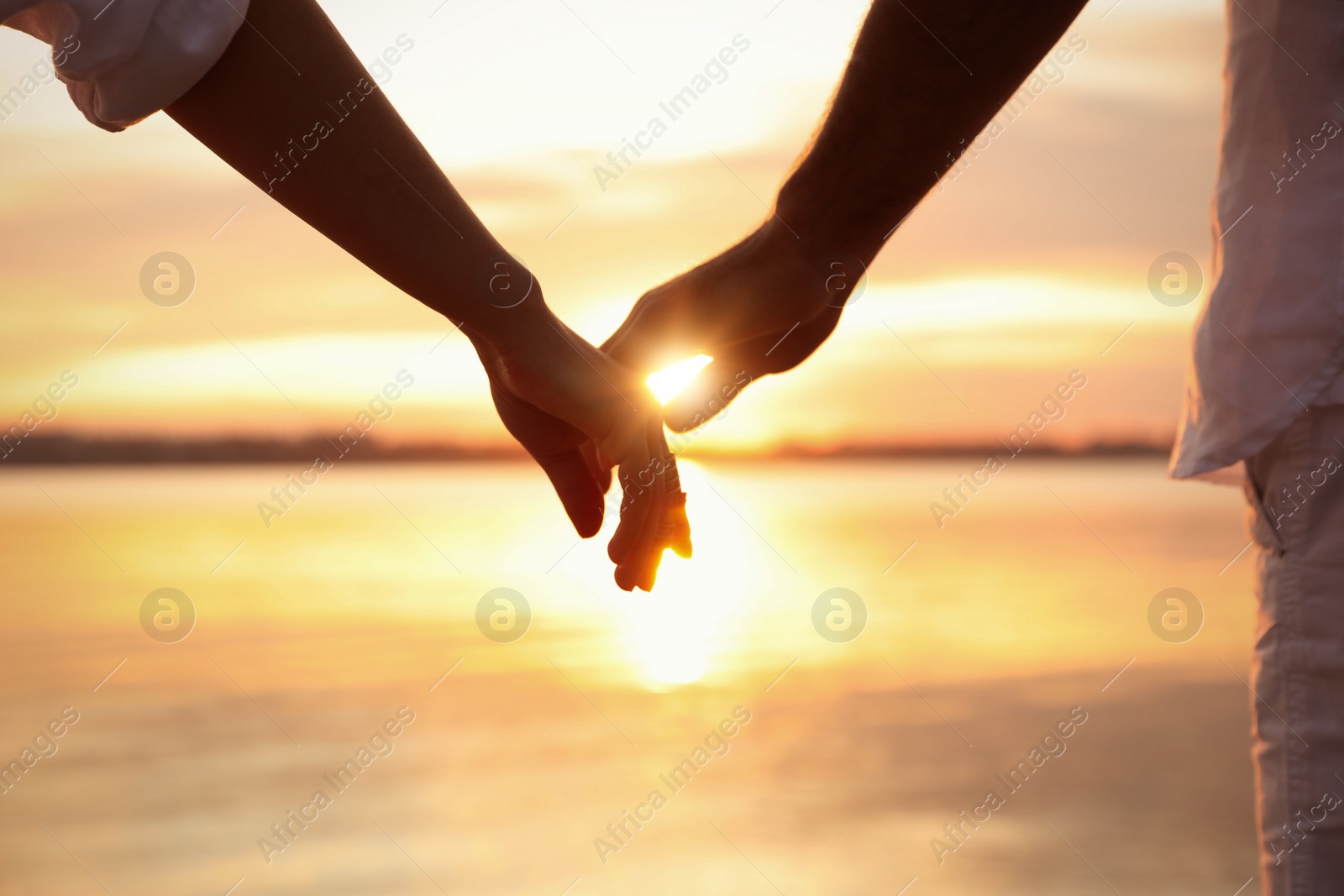 Photo of Man and woman reaching hands to each other at sunset, closeup. Nature healing power