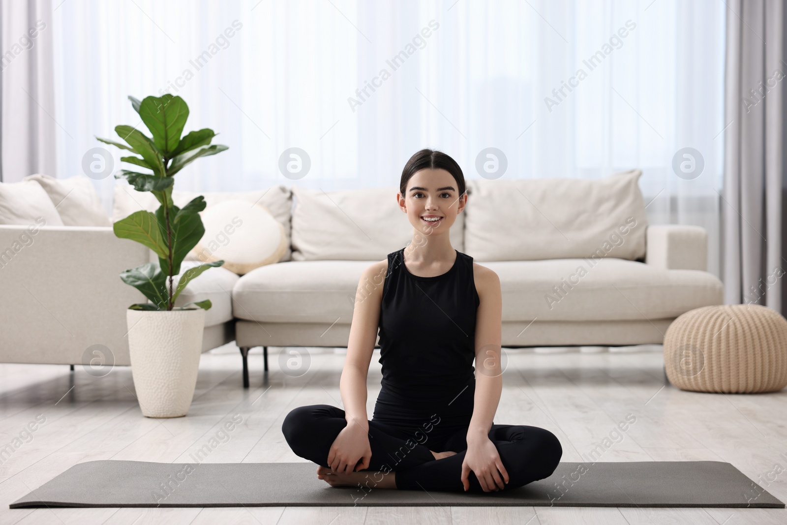 Photo of Beautiful girl meditating on yoga mat at home