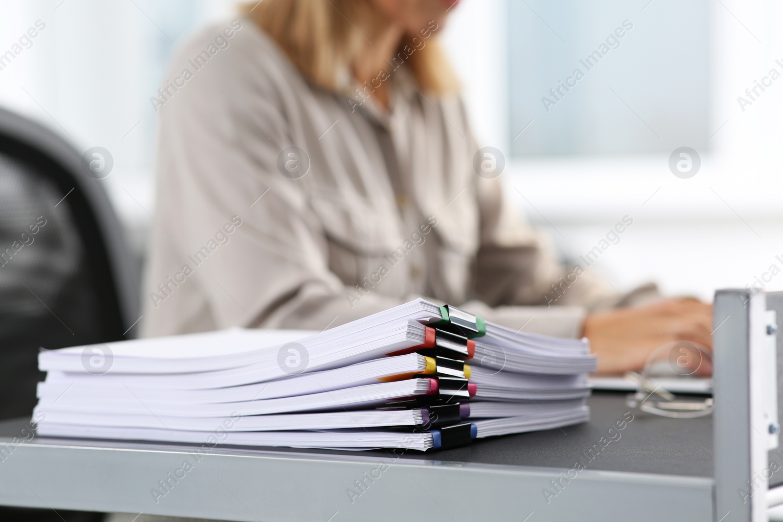 Photo of Businesswoman working with laptop at table in office, focus on documents