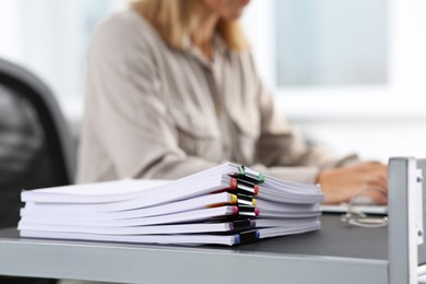 Businesswoman working with laptop at table in office, focus on documents