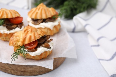 Delicious profiteroles with cream cheese, mushrooms, tomato and dill on white table, closeup. Space for text
