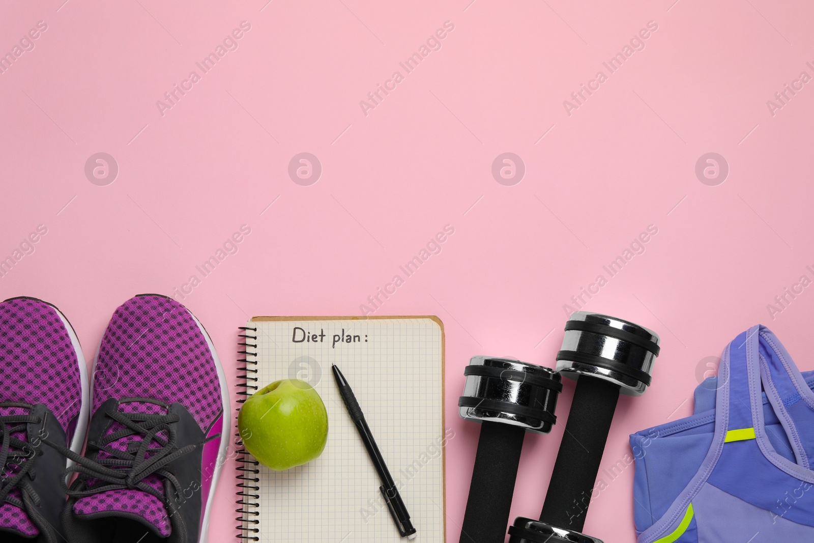 Photo of Weight loss concept. Flat lay composition with sneakers, fitness items and notebook on pink background, space for text