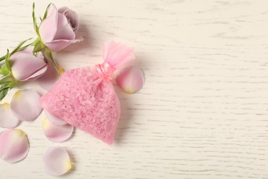 Scented sachet and roses on white wooden table, flat lay. Space for text