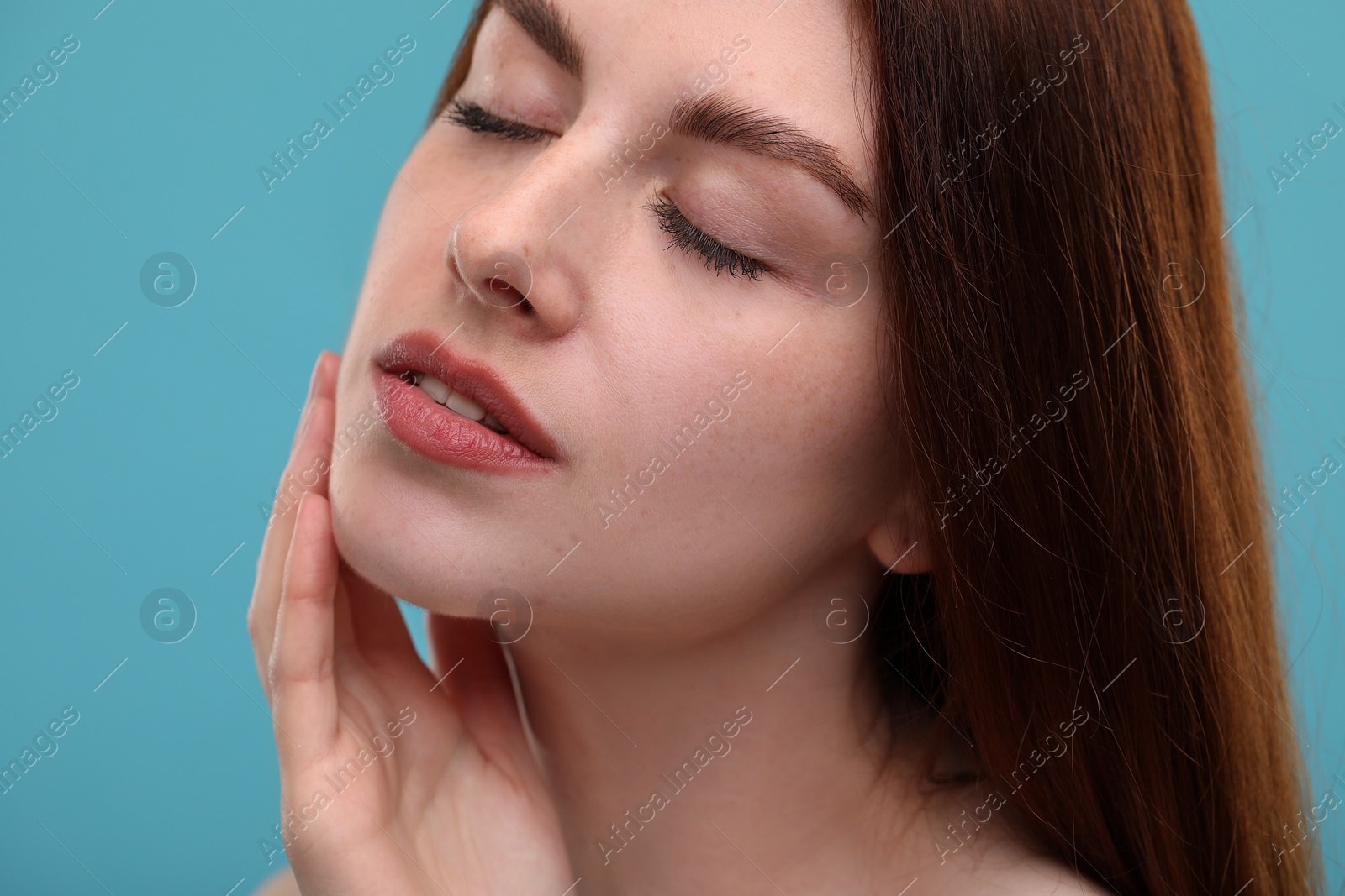 Photo of Portrait of beautiful woman with freckles on light blue background, closeup