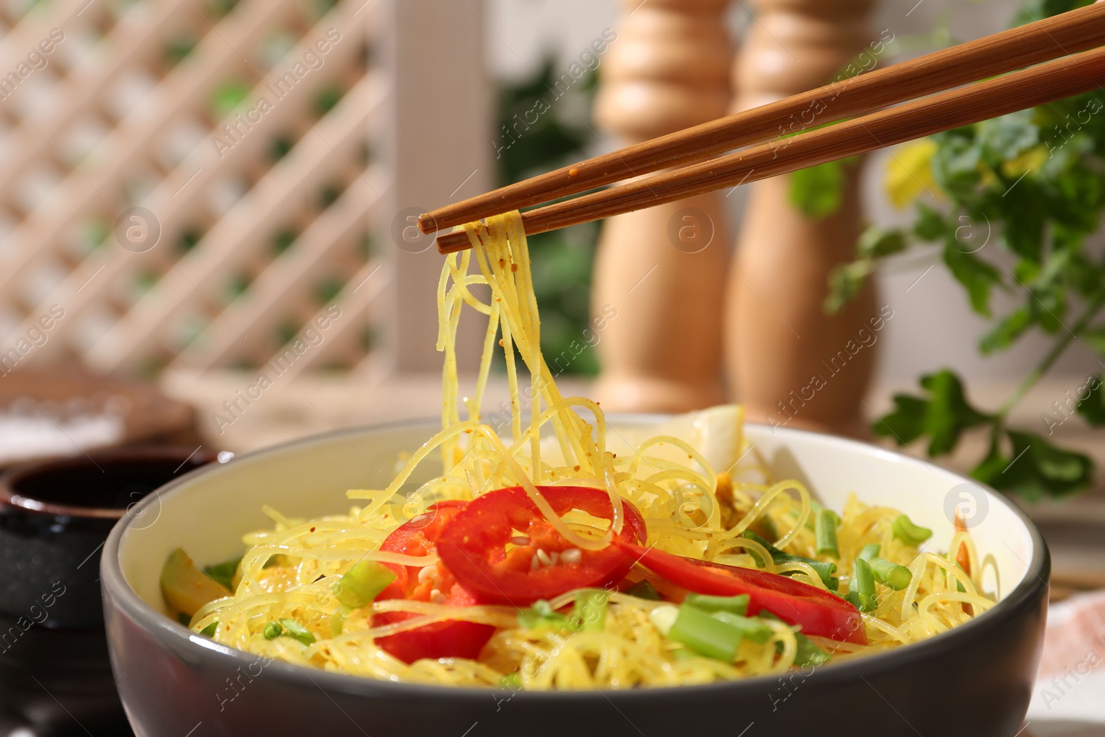 Photo of Stir-fry. Eating tasty noodles with meat and vegetables at table, closeup