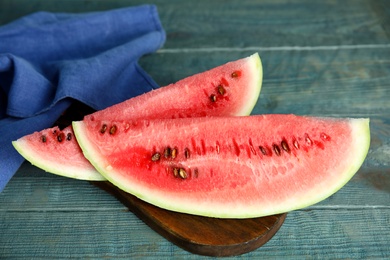 Photo of Board with yummy watermelon slices on wooden table