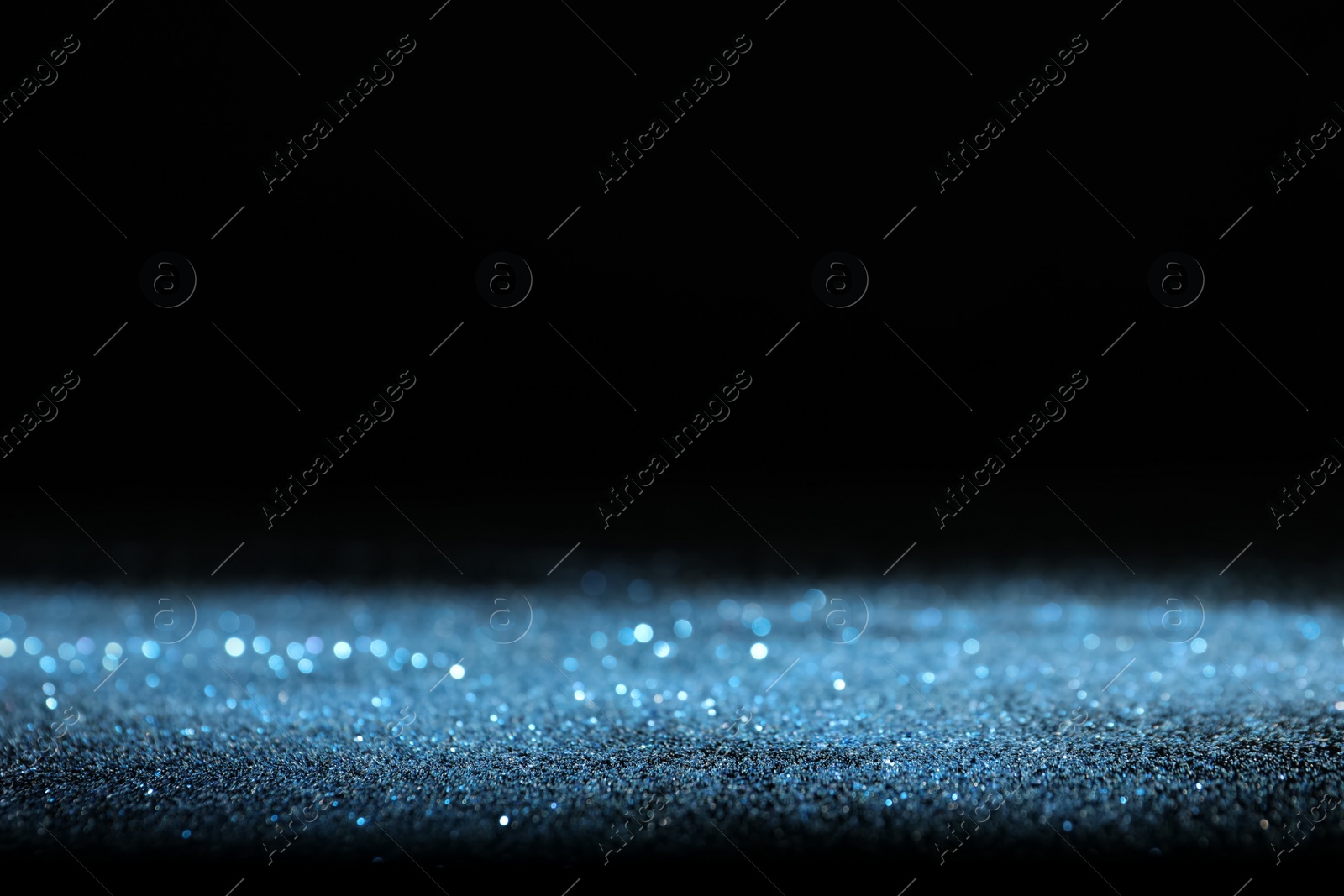Photo of Shiny blue glitter on black background, space for text. Bokeh effect