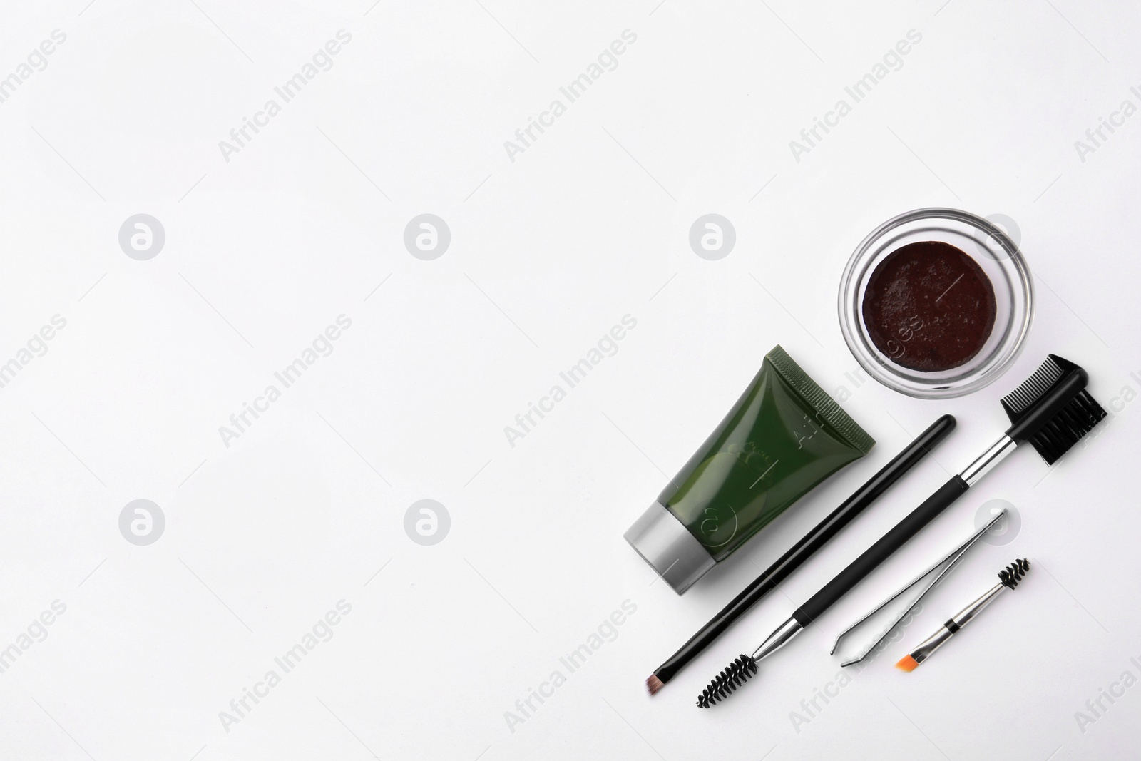 Photo of Flat lay composition with eyebrow henna, professional tools and cosmetic product on white background, space for text