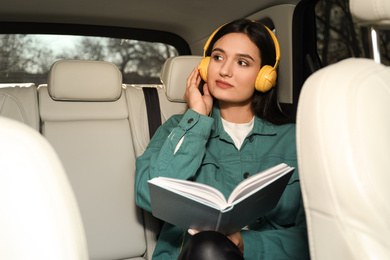 Photo of Young woman listening to audiobook in car