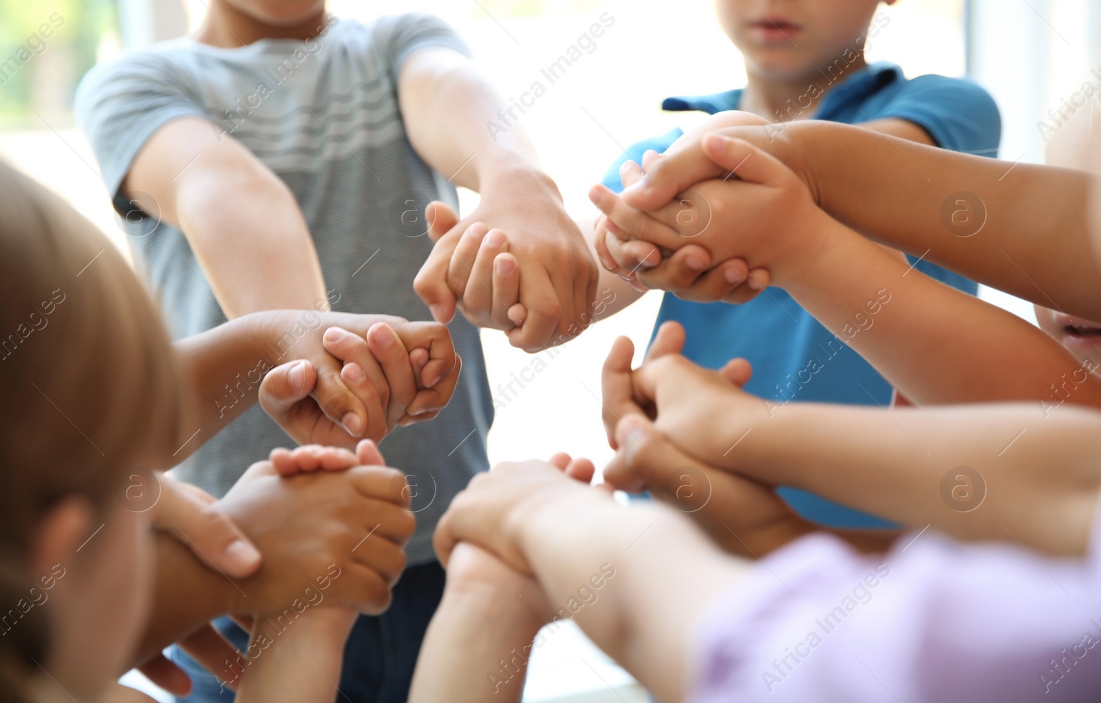 Photo of Little children holding their hands together, closeup. Unity concept