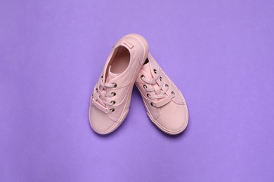 Photo of Pair of comfortable sports shoes on violet background, flat lay
