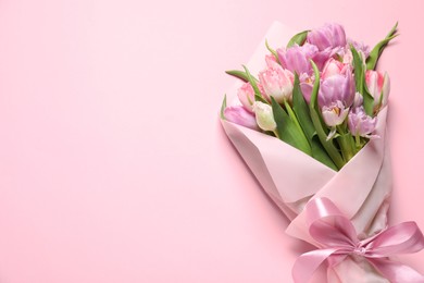 Photo of Beautiful bouquet of colorful tulip flowers on pink background, top view. Space for text