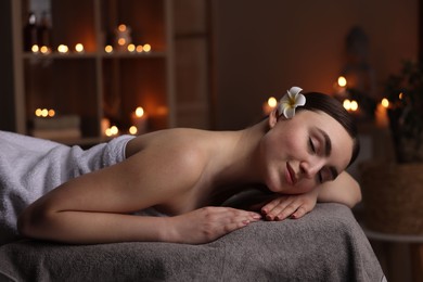 Photo of Spa therapy. Beautiful young woman lying on massage table in salon