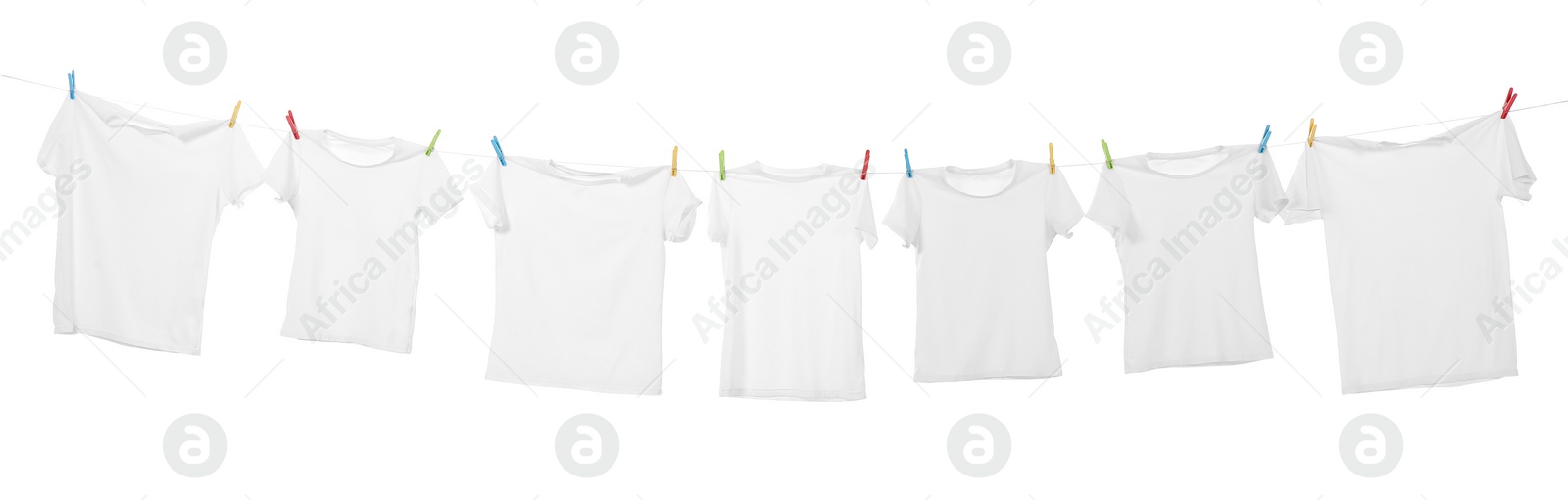 Photo of Many t-shirts drying on washing line isolated on white