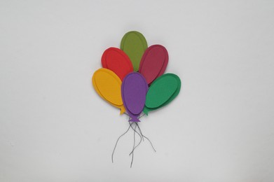 Colorful paper balloons on white background, top view