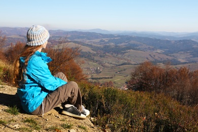 Woman in warm clothes enjoying mountain landscape