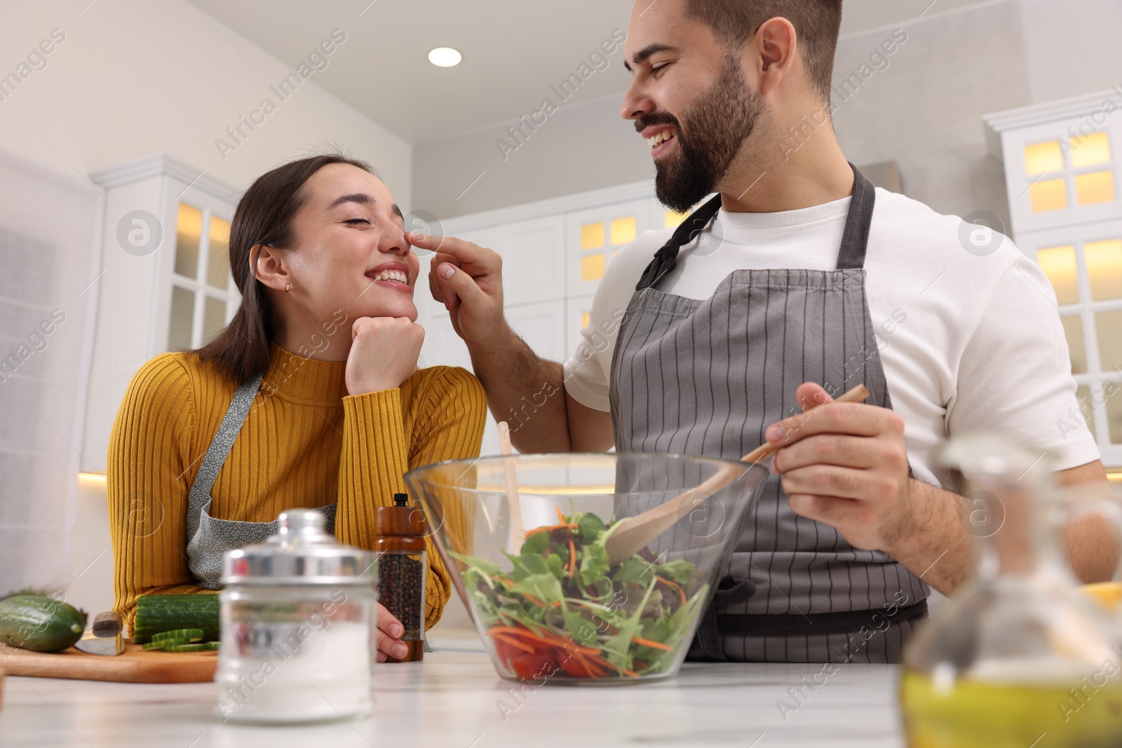 Photo of Lovely couple cooking together in kitchen, low angle view