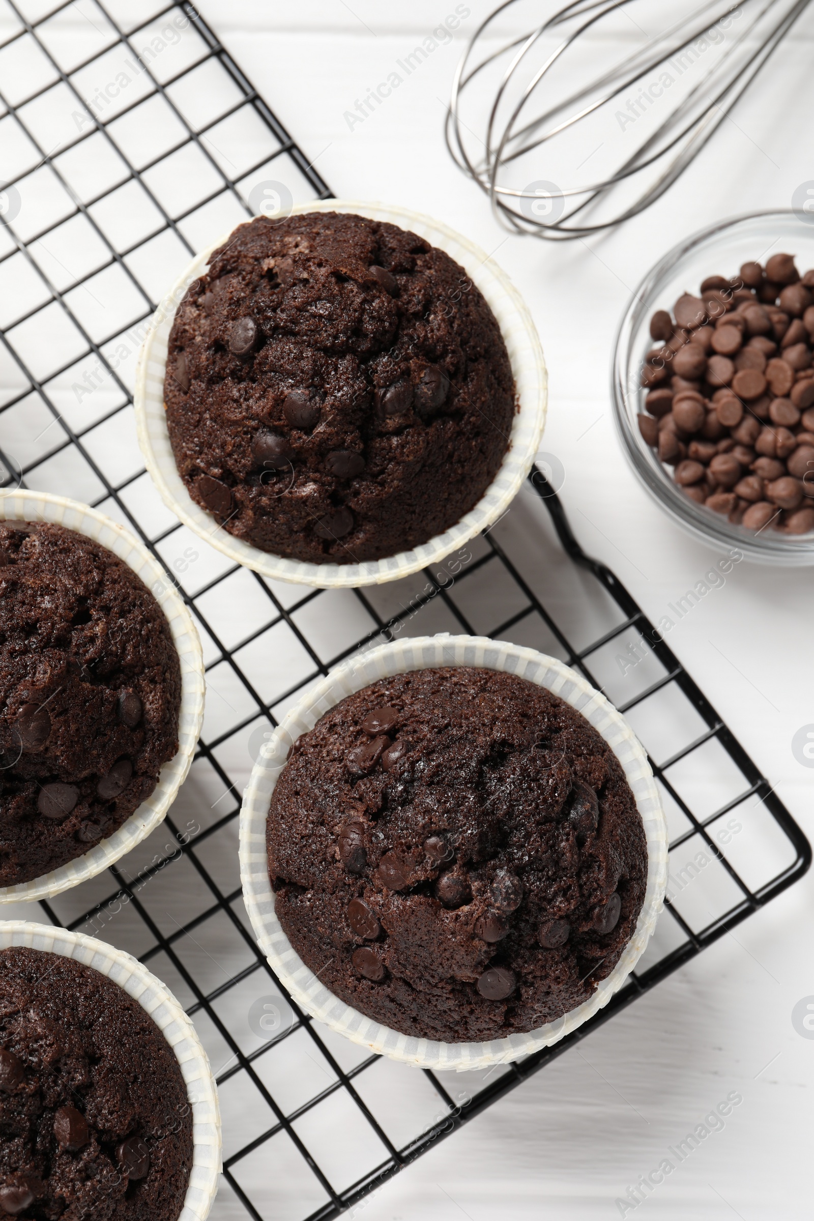 Photo of Tasty chocolate muffins on white wooden table, flat lay