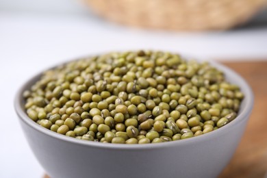 Photo of Bowl with green mung beans on white table, closeup