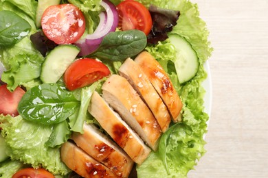 Delicious salad with chicken and vegetables on table, top view