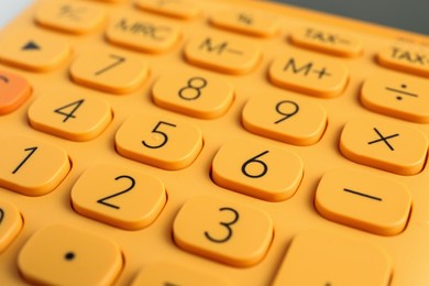 Closeup view of orange calculator as background