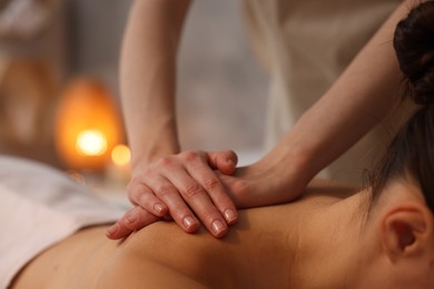 Photo of Woman receiving back massage in spa salon, closeup