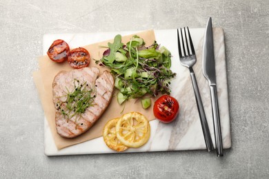 Photo of Delicious tuna steak served on light grey table, top view